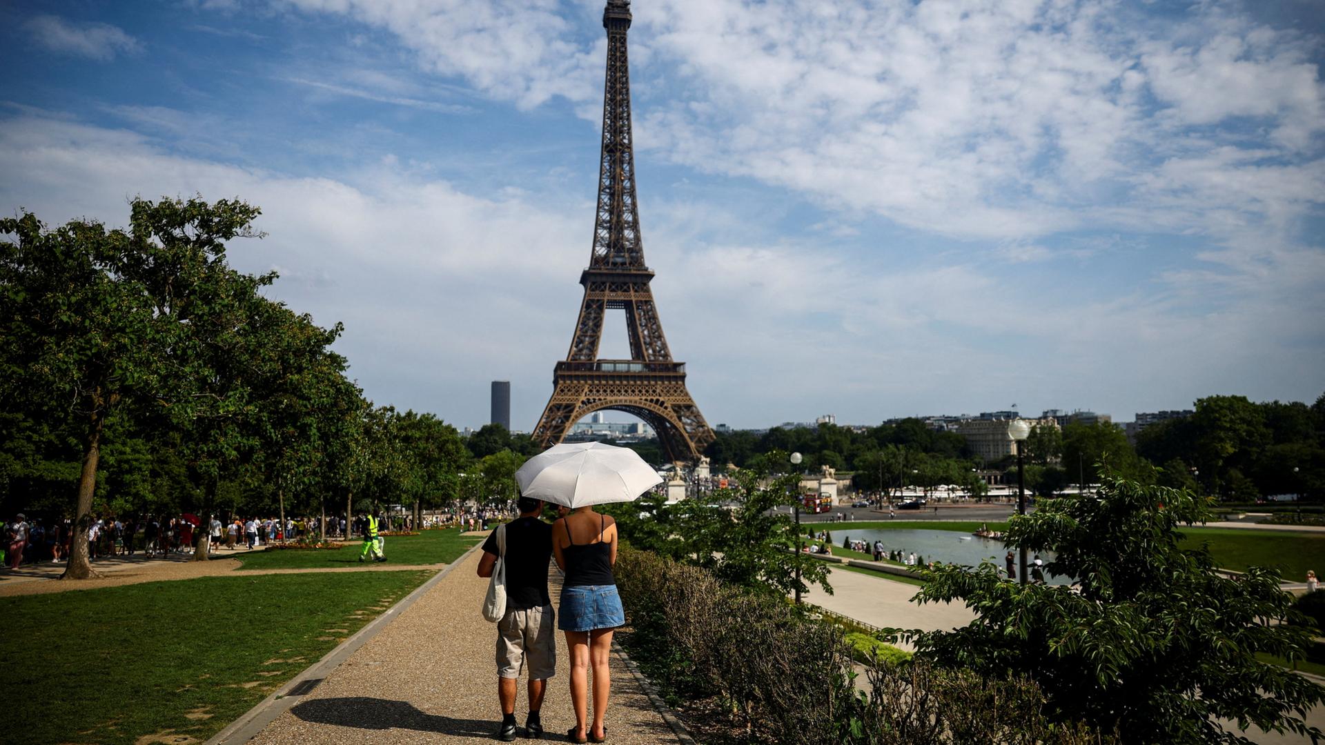Menschen gehen vor dem Eiffelturm in Paris, Frankreich. | REUTERS