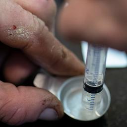 Nachdem sie die Cracksteine mit Hilfe von Wasser und Ascorbin aufgelöst hat, zieht eine drogenabhängige Frau das Crack in einer Spritze auf.