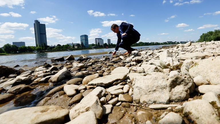 Carsten Schneider am niedrig stehenden Rhein in Bonn (aufgenommen am 19. Mai 2025)