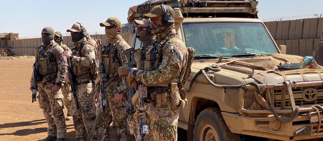 Zur Ausbildung und Beratung eingesetzte Kampfschwimmer der deutschen Marine stehen neben einem Geländefahrzeug in Tillia, Niger.