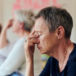 Eine Gruppe Rentnerinnen macht Atemübungen beim Yoga.